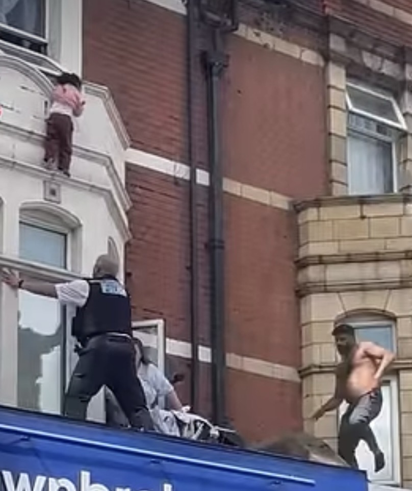 Shirtless man swoops&nbsp;in to catch a young girl as she falls from&nbsp;a window ledge above a busy shopping strip.&nbsp;